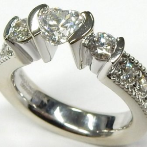 Estate Diamond Engagement Ring 
14 Karat White Estate Engagement Ring Width 4.3mm 
Finger Size 5.5 Gram Weight 8.2 
1 Center Diamond 0.60ct Shape: Heart; Clarity: SI1; Colour: F; GIA 6137286686 With 2 Round Diamonds 0.31 ctw and 6 Round Diamonds 0.31 c