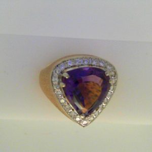 Amethyst Estate Ring
14 Karat Yellow/White Amethyst Ring With Finger Size 7.75
Width 3.7mm Gram Weight 7.3
1 Center Amethyst 4.50ct Shape: Trillian With 25 Round Diamonds 0.33 ctw