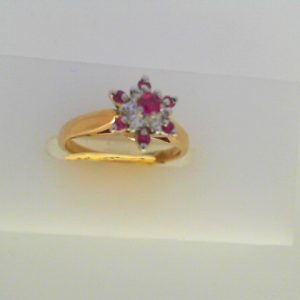 Rubies Estate Ring
10K/14K Yellow/White Rubies Ring With Finger Size 5
Width 1.3mm Gram Weight 2.4
7 Center Rubies Shape: Round With 6 Round Diamonds 0.15 ctw