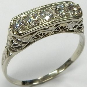 Estate Diamond Dinner Ring - Women's 
18 Karat White Estate Dinner Ring Width 5.9mm 
Finger Size 10.25 Gram Weight 2.7 
5 Center Diamonds Shape: EURO Cut; Clarity: I1; Colour: H/I 0.6 (centre diamond badly chiipped).