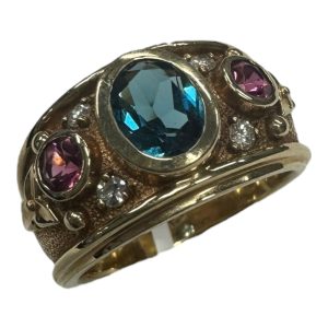 Topaz Ring 
14 Karat Yellow Topaz Ring With Finger Size 7 
Width 4.74mm Gram Weight 7.65 
1 Center Topaz Shape: Oval With 2 Round Tourmalines and 4 Round Diamonds 0.12 ctw