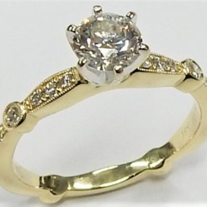 Estate Diamond Engagement Ring 
18 Karat Yellow/White Estate Engagement Ring 
Finger Size 4.75 
 Center Diamond Shape: Round; Clarity: SI1; Colour: J Round Diamond 0.27 ctw 0.79