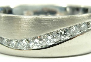 Estate Diamond Dinner Ring - Women's 
18 Karat White Estate Dinner Ring Width 6mm 
Finger Size 4.5 Gram Weight 7.9 
13 Center Diamonds Shape: Round; Clarity: VS1; Colour: F/G 0.18