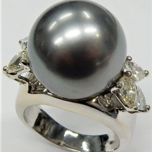 Estate Diamond Dinner Ring - Women's 
18 Karat White Estate Dinner Ring 
 Gram Weight 12.9 
6 Center Diamonds Shape: Pear; Clarity: VS; Colour: J With 1 Tahitian Pearl 1.2