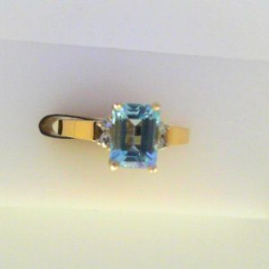 Topaz Ring 
14 Karat Yellow/White Topaz Ring With Finger Size 6 
Width 2mm Gram Weight 2.69 
1 Center Topaz Shape: Emerald With 4 Round Diamonds
