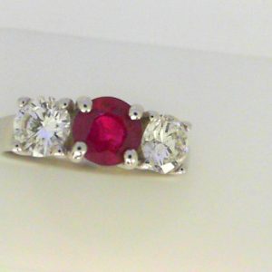 Ruby Ring 
14 Karat White Ruby Ring With Finger Size 6 
Width 2.5mm Gram Weight 3.9 
1 Center Ruby 0.79ct Shape: Round With 2 Round Diamonds 0.90 ctw