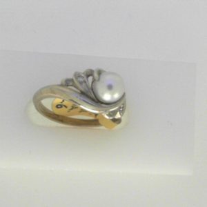 Pearl Estate Ring 
10 Karat White Pearl Ring With Finger Size 6 
Width 1.95mm Gram Weight 3.03 
1 Center Pearl Shape: Round With 2 Round Diamonds
