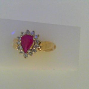 Ruby Estate Ring 
10 Karat Yellow/White Ruby Ring With Finger Size 6.5 
Width 2.3mm Gram Weight 4.6 
1 Center Ruby Shape: Pear With 13 Round Diamonds 0.25 ctw
