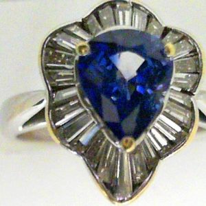 Sapphire Estate Ring 
18 Karat Yellow/White Violetish Blue Sapphire Ring With Finger Size 7 
Width 3mm Gram Weight 4.8 
1 Center Sapphire 1.66ct Shape: Pear; Clarity: VS; Colour: Violetish Blue With 26 Baguette Diamonds 0.52 ctw