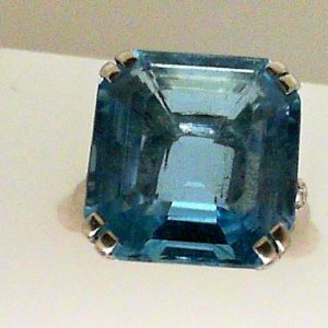 Aqua Birks-Ellis Estate Ring
Platinum White Blue Aqua Ring With Finger Size 5.75
Gram Weight 6.43
1 Center Aqua 15.37ct Shape: Emerald; Colour: Blue With 4 Round Diamonds 0.14 ctw