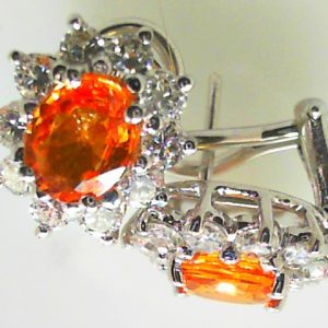 Estate Earrings With Sapphires 
18 Karat White Orange Sapphires Earrings 
 Gram Weight 5.9 
2 Center Sapphires Shape: Oval; Colour: Orange With 20 Round Diamonds 1.50 ctw