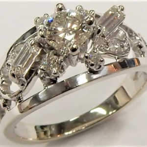 Estate Diamond Dinner Ring - Women's 
14 Karat White Estate Dinner Ring 
 Gram Weight 5.1 
1 Center Diamond; 0.53ct Shape: Round; Clarity: VS1; Colour: H With 8 Various Shapes Diamonds 0.20 ctw 0.73