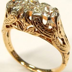 Estate Diamond Dinner Ring - Women's 
14 Karat Yellow Estate Dinner Ring Width 7.4mm 
Finger Size 5 Gram Weight 3.18 
2 Center Diamonds Shape: EURO Cut; Clarity: I1; Colour: H/I With 1 EURO Cut Diamond 0.30 ctw 0.72