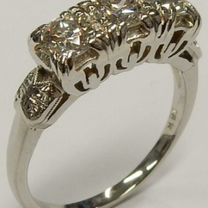 Estate Diamond Dinner Ring - Women's 
18 Karat White Estate Dinner Ring 
Finger Size 6 Gram Weight 3.99 
3 Center Diamonds Shape: Round; Clarity: VS1; Colour: H 0.9