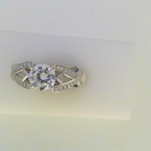 Diamond Semi-Mount Ring 
18 Karat White Ring 
Finger Size 6 
 Center Diamond Shape: Round; Clarity: VS1; Colour: F/G 0.33