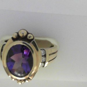 Amethyst Ring 
14 Karat Yellow Amethyst Ring With Finger Size 6.5 
Width 2.65mm 
1 Center Amethyst Shape: Oval With 6 Round Diamonds