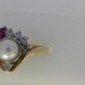 Pearl Ring 
14 Karat Yellow Pearl Ring With Finger Size 6.5 
Width 3mm Gram Weight 4.11 
1 Center Pearl Shape: Round With 2 Marquise Rubies and 5 Round Diamonds 0.15 ctw