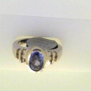 Tanzanite Ring 
14 Karat White Tanzanite Ring With Finger Size 6.25 
Width 2.39mm Gram Weight 6.01 
1 Center Tanzanite Shape: Oval With 10 Round Diamonds 0.20 ctw