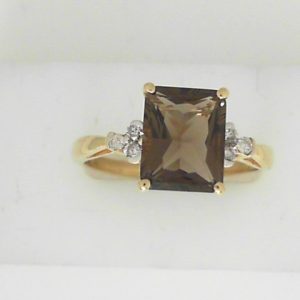 Smokey Quartz Estate Ring 
10 Karat Yellow Brown Smokey Quartz Ring With Finger Size 10 
 Gram Weight 2.93 
1 Center Smokey Quartz 2.87ct Shape: Emerald; Colour: Brown With 6 Round Diamonds 0.10 ctw