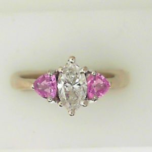 Diamond and Pink Sapphire Estate Ring 
18 Karat White I Diamond Ring With Finger Size 5.75 
 Gram Weight 2.7 
1 Center Diamond 0.64ct Shape: Marquise; Clarity: I1; Colour: I With 2 Trillian Sapphires