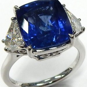 Sapphire Estate Ring 
18 Karat White Blue Sapphire Ring With Finger Size 6.5 
Width 2mm Gram Weight 6.6 
1 Center Sapphire 8.46ct Shape: Cushion; Clarity: SI1; Colour: Blue With 2 Trapezoid Diamonds 1.50 ctw