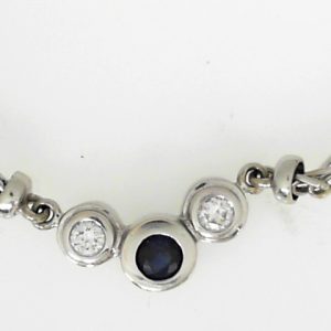 Sapphire Estate Pendant 
14 Karat White Sapphire Pendant 
Gram Weight 13 Chain Style: Wheat 14 Karat White Length: 18in 
1 Center Sapphire Shape: Round With 2 Round Diamonds 0.16 ctw