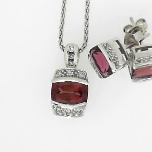 Garnets Estate Pendant 
10 Karat White Purple Red Garnets Pendant 
Gram Weight 5.5 Chain Style: Wheat 10 Karat White Length: 18in 
3 Center Garnets Shape: Various Shapes; Colour: Purple Red With 21 Round Diamonds