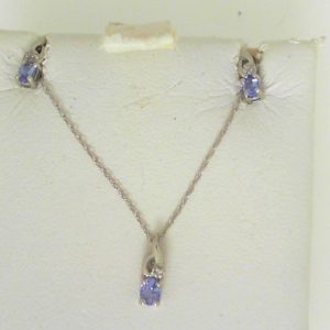 Tanzanites Estate Pendant 
10 Karat White Tanzanites Pendant 
Gram Weight 0.83 Chain Style: Cable Link 10 Karat White Length: 18in 
3 Center Tanzanites Shape: Oval With 3 Round Diamonds
