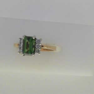 Tourmaline Ring 
14 Karat Yellow/White Green Tourmaline Ring With Finger Size 5.25 
Width 3.05mm Gram Weight 3.05 
1 Center Tourmaline 0.70ct Shape: Emerald; Colour: Green With 6 Round Diamonds 0.12 ctw