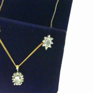 Moonstone Pendant 
10 Karat Yellow/White Moonstone Pendant 
 Chain Style: Curb 10 Karat Yellow Length: 18in 
1 Center Moonstone Shape: Oval Round Diamond 0.11 ctw