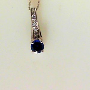 Sapphire Pendant 
18 Karat White Sapphire Pendant 
 
1 Center Sapphire 0.46ct Shape: Round With 7 Round Diamonds 0.07 ctw